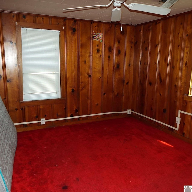 unfurnished room featuring carpet floors and wood walls