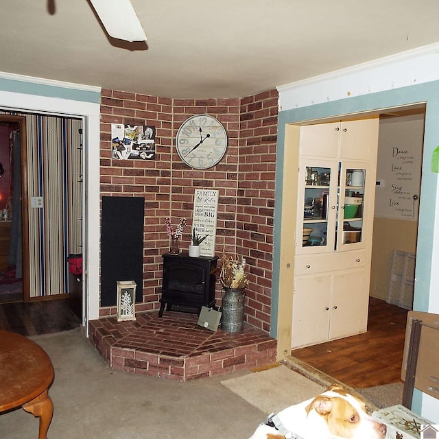 living room with dark carpet, a wood stove, and crown molding