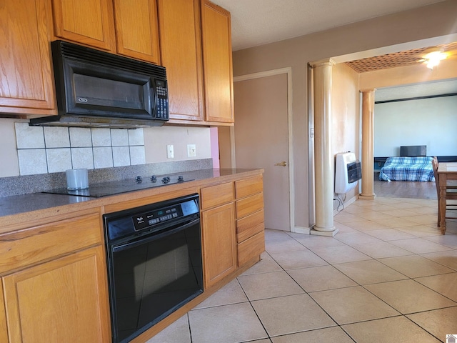 kitchen featuring dark countertops, black appliances, and ornate columns