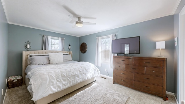 bedroom with light colored carpet, a ceiling fan, visible vents, baseboards, and crown molding