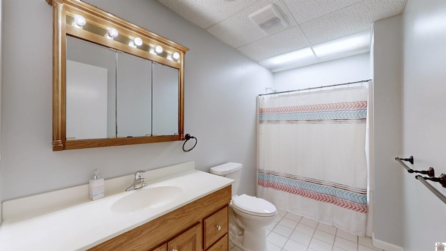 bathroom with a drop ceiling, toilet, vanity, visible vents, and a shower with curtain