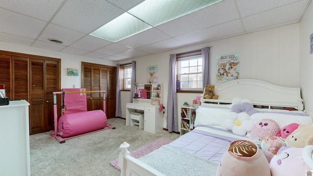 bedroom featuring a paneled ceiling, visible vents, and light carpet