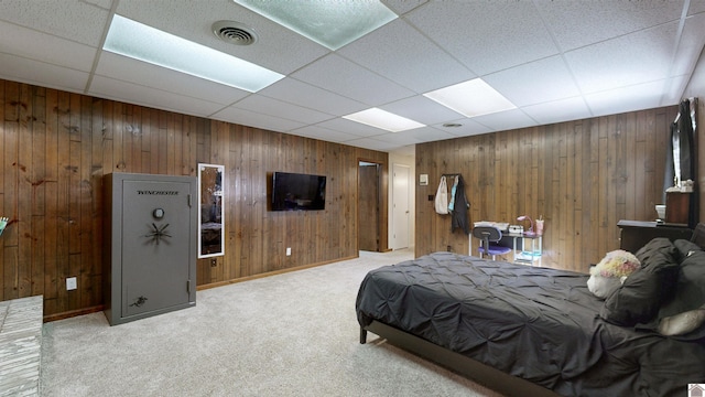 bedroom with visible vents, wood walls, light carpet, and baseboards