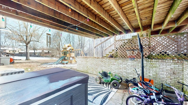 view of patio with a playground and fence