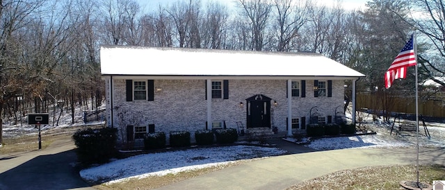 bi-level home featuring entry steps and brick siding