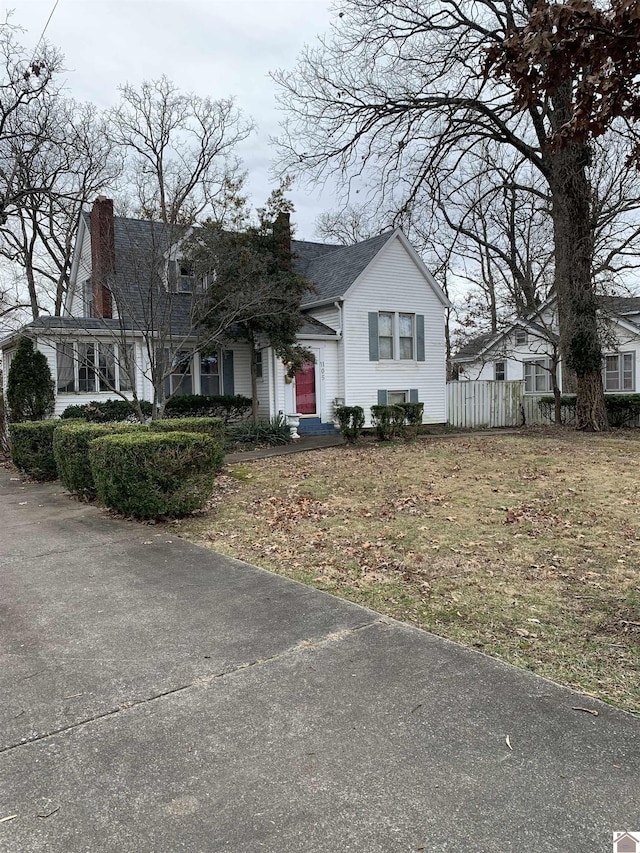 view of front of home with a chimney and fence