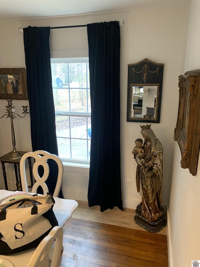 sitting room featuring a wealth of natural light, baseboards, and wood finished floors