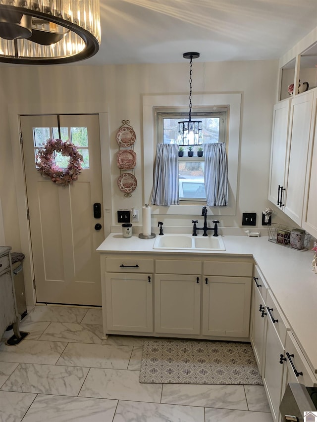 kitchen with marble finish floor, a wealth of natural light, light countertops, and a sink