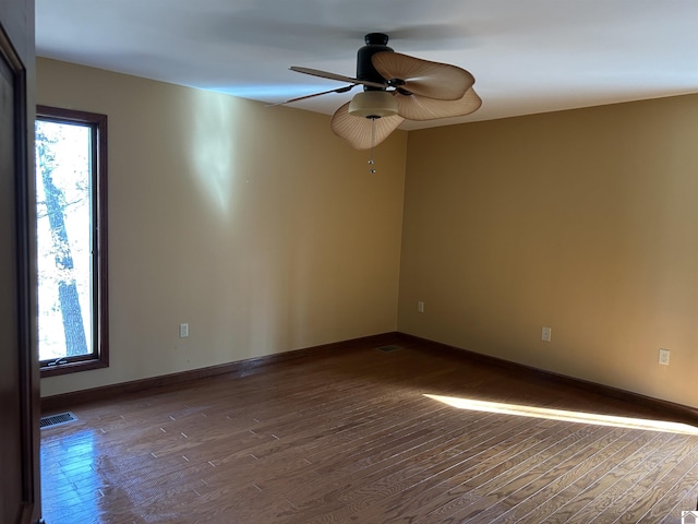 unfurnished room featuring visible vents, baseboards, and wood finished floors