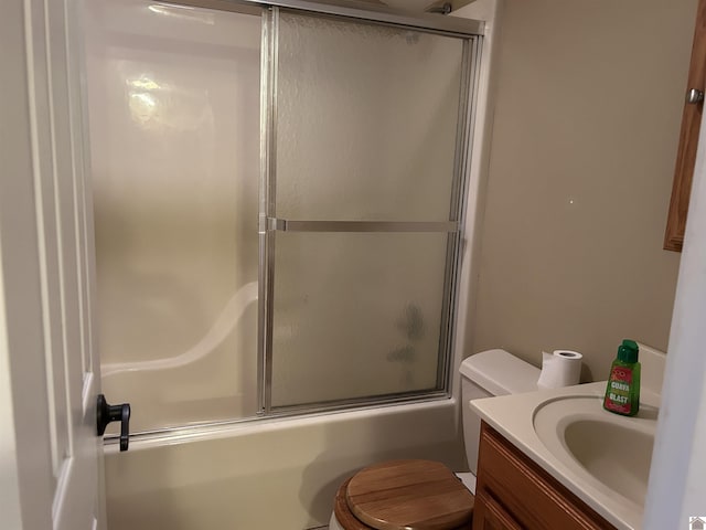 bathroom with vanity, toilet, and bath / shower combo with glass door