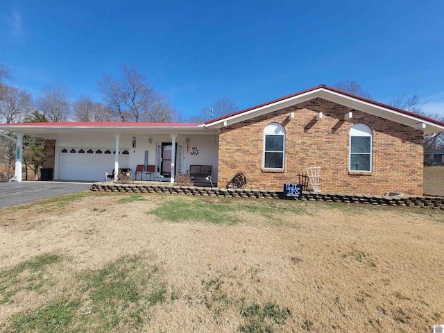 ranch-style house with covered porch, driveway, brick siding, and a garage