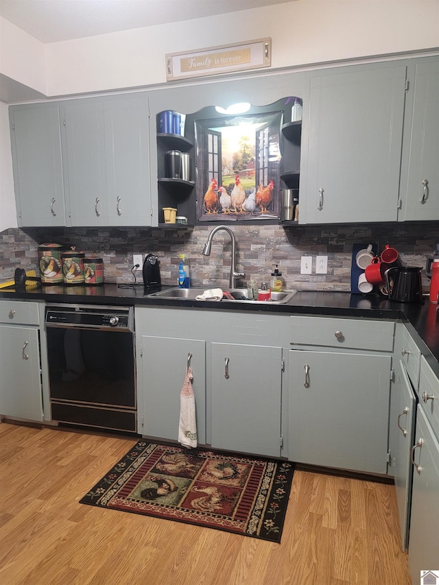 kitchen with black dishwasher, open shelves, dark countertops, gray cabinetry, and a sink