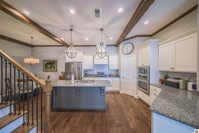 kitchen with stainless steel appliances, hanging light fixtures, and white cabinets