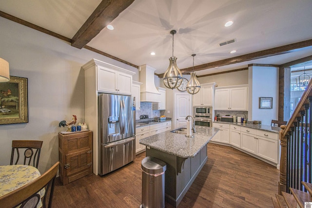 kitchen featuring visible vents, hanging light fixtures, custom exhaust hood, stainless steel appliances, and a sink