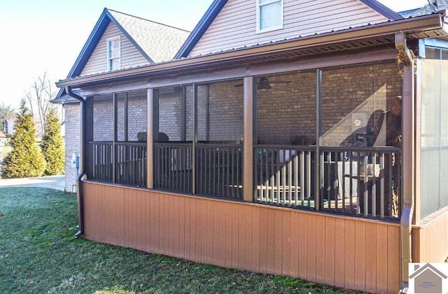 view of side of property featuring a sunroom and brick siding