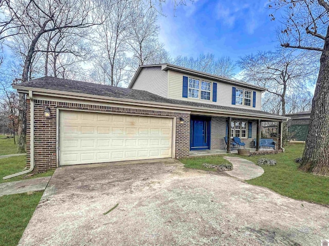 traditional home featuring brick siding, concrete driveway, covered porch, a front yard, and a garage