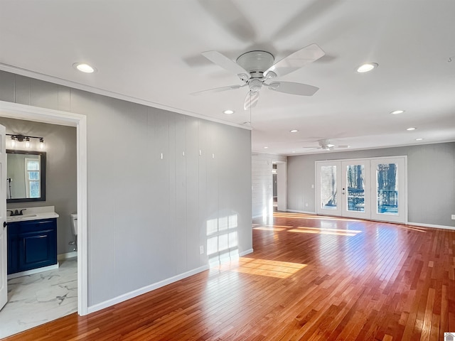 unfurnished living room featuring hardwood / wood-style flooring, baseboards, ornamental molding, and recessed lighting