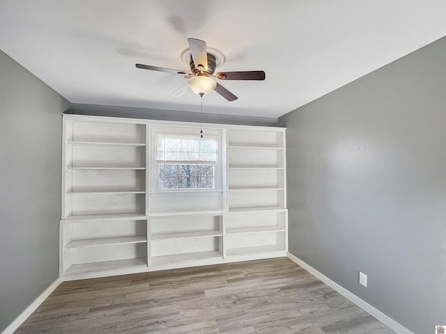 unfurnished dining area featuring a ceiling fan, baseboards, and wood finished floors