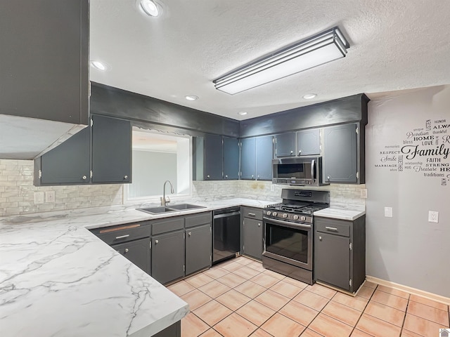 kitchen with light tile patterned floors, a sink, light countertops, appliances with stainless steel finishes, and tasteful backsplash