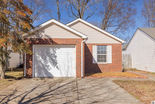 view of front of property featuring a garage, concrete driveway, and brick siding