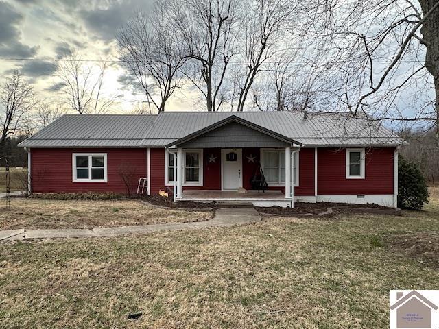 ranch-style home featuring crawl space, covered porch, metal roof, and a front lawn