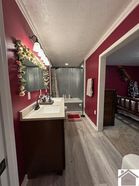 full bath with crown molding, curtained shower, vanity, a textured ceiling, and wood finished floors