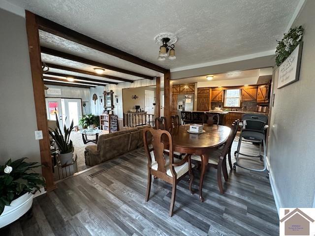 dining area with dark wood-style floors, french doors, a textured ceiling, and beamed ceiling