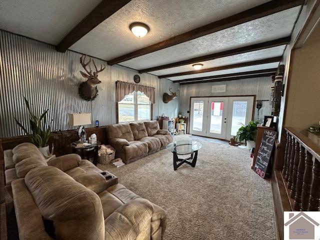 living room featuring beam ceiling, french doors, a textured ceiling, and carpet flooring