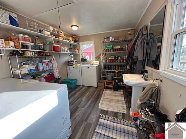 storage area featuring independent washer and dryer and a sink