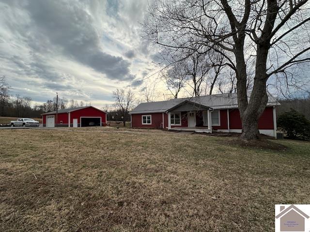 ranch-style house with an outdoor structure, a detached garage, and a front lawn