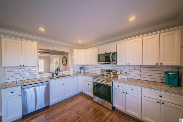 kitchen with appliances with stainless steel finishes, dark wood-type flooring, a sink, and white cabinets