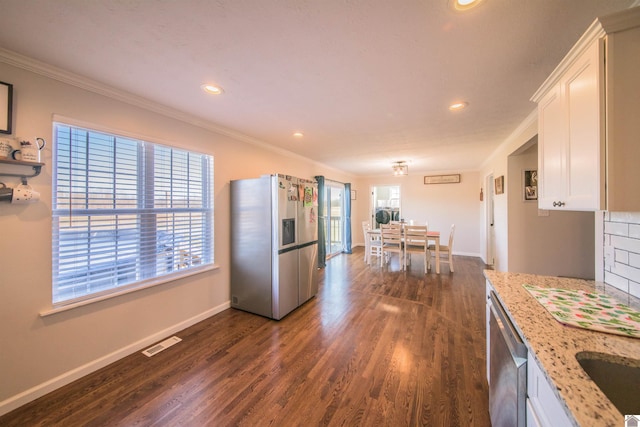 kitchen featuring appliances with stainless steel finishes, visible vents, ornamental molding, and white cabinetry