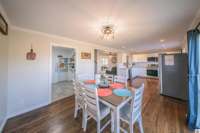 dining space featuring dark wood-style flooring, crown molding, and baseboards