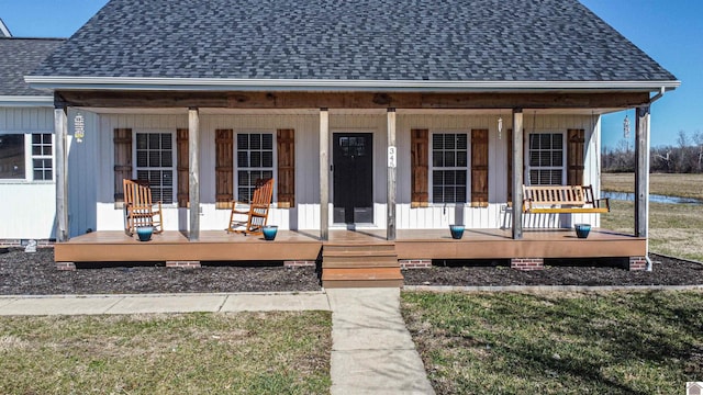 exterior space featuring covered porch and a shingled roof