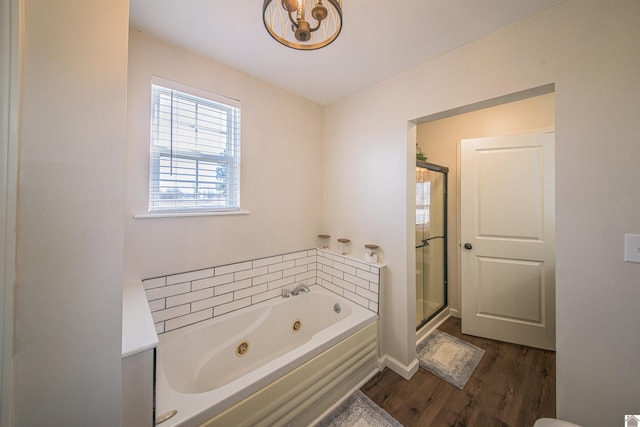 bathroom featuring a jetted tub, a stall shower, and wood finished floors