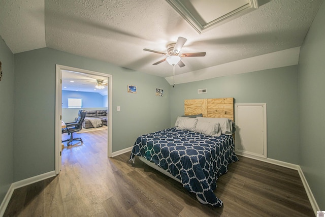 bedroom featuring lofted ceiling, visible vents, dark wood finished floors, and baseboards