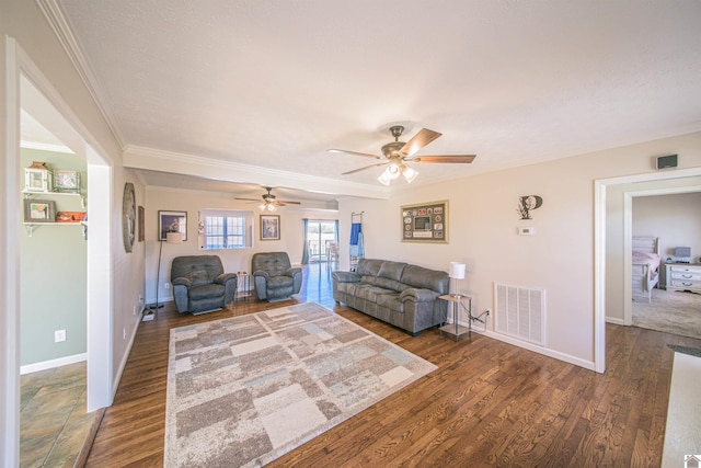 unfurnished living room featuring baseboards, crown molding, visible vents, and dark wood-type flooring