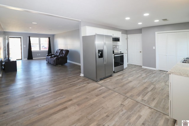 kitchen with light wood-style flooring, recessed lighting, white cabinetry, baseboards, and appliances with stainless steel finishes