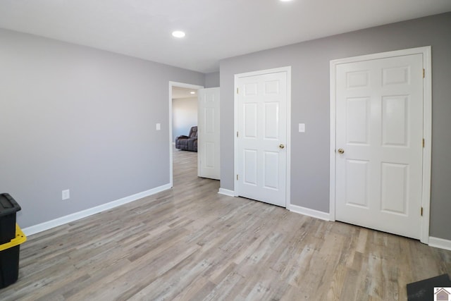 unfurnished bedroom featuring recessed lighting, light wood finished floors, and baseboards