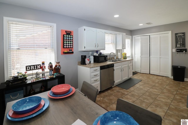 kitchen featuring dishwasher, a sink, black microwave, and white cabinetry