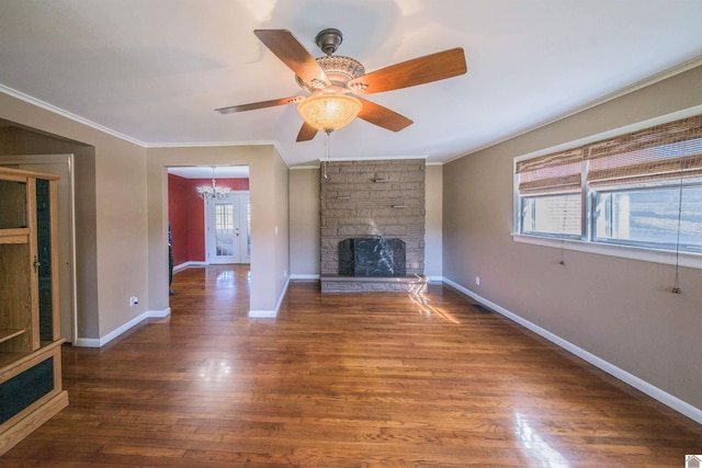 unfurnished living room with ornamental molding, a fireplace, baseboards, and wood finished floors