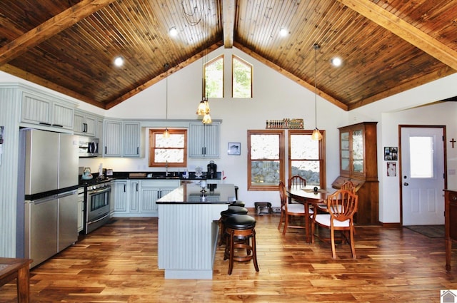 kitchen with stainless steel appliances, dark countertops, wood ceiling, and wood finished floors