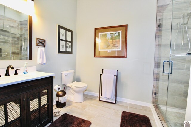 full bath featuring a stall shower, vanity, toilet, and baseboards