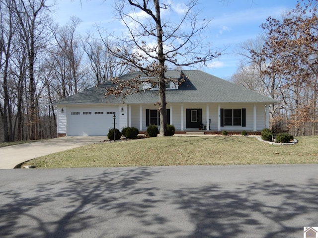 view of front of property with a front yard, concrete driveway, covered porch, and an attached garage