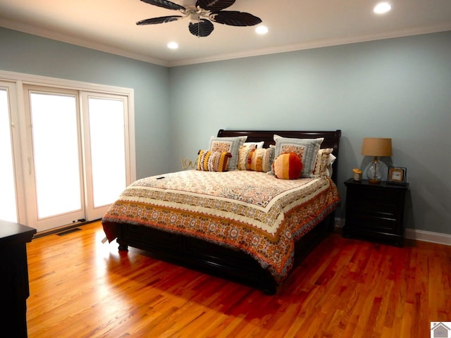 bedroom featuring baseboards, recessed lighting, wood finished floors, and crown molding