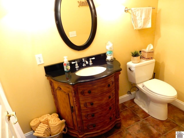 half bath with tile patterned flooring, vanity, toilet, and baseboards