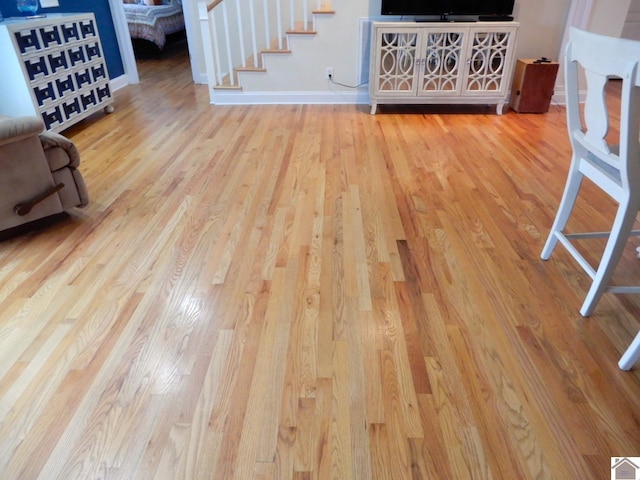 unfurnished living room featuring baseboards and wood finished floors