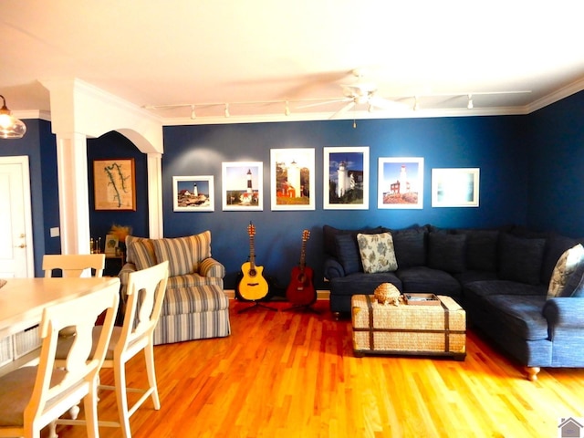 living room featuring ornamental molding, a ceiling fan, track lighting, wood finished floors, and ornate columns