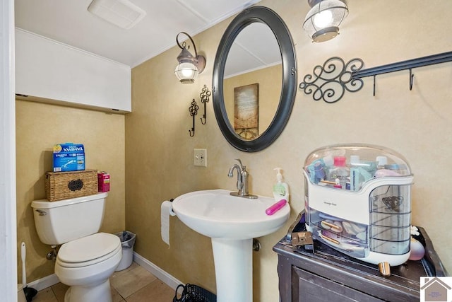 bathroom with tile patterned flooring, baseboards, a sink, and toilet