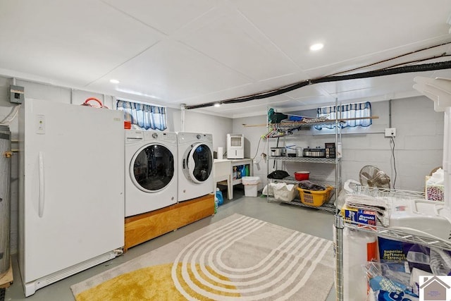 clothes washing area with concrete block wall and washing machine and clothes dryer